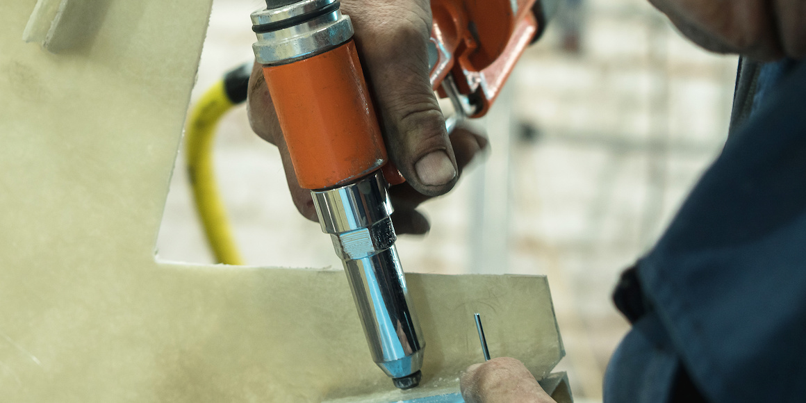 Professional Installing a Semi-Tubular Rivet Using an Orange Rivet Gun